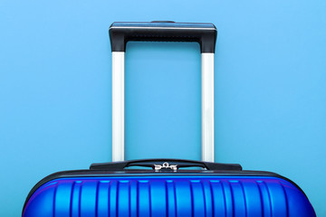 Modern Phantom Blue classic blue suitcase on blue background close up with copy space for text. Minimal style travel concept. Vacation trip. Summer holiday stock photo. Trendy color 2020 classic blue