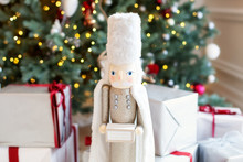 Classic Vintage Nutcracker On New Year Background. Wooden Toy Nutcracker, Classic Decorations. Christmas Mood In Children Room. Soldier Nutcracker Statue Standing In Front Of Decorated Christmas Tree