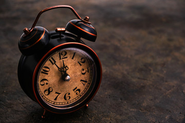 Old retro alarm clock on concrete vintage background.