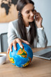 © LIGHTFIELD STUDIOS - selective focus of travel agent holding hand on globe