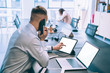 © GalakticDreamer - Businessman talking on phone while surfing laptops in office
