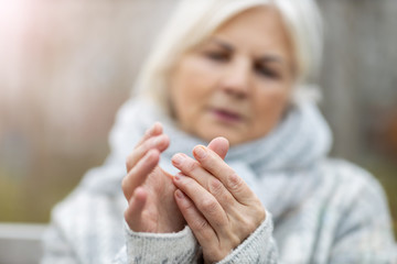 Canvas Print - Senior woman with arthritis rubbing hands