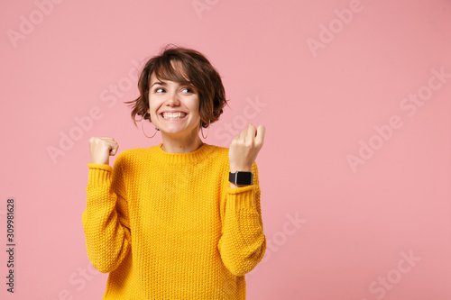 Fotografía Joyful young brunette woman girl in yellow sweater posing isolated on pink background studio portrait