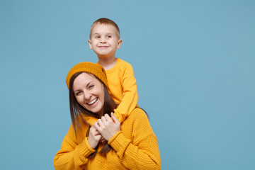 Wall Mural - Woman in yellow clothes have fun posing with cute child baby boy 4-5 years old. Mommy little kid son isolated on blue background studio portrait. Mother's Day love family parenthood childhood concept.