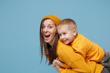 Wall Mural - Woman in yellow clothes have fun posing with cute child baby boy 4-5 years old. Mommy little kid son isolated on blue background studio portrait. Mother's Day love family parenthood childhood concept.