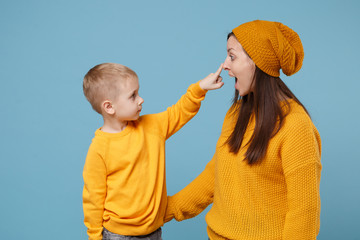 Wall Mural - Woman in yellow clothes have fun posing with cute child baby boy 4-5 years old. Mommy little kid son isolated on blue background studio portrait. Mother's Day love family parenthood childhood concept.