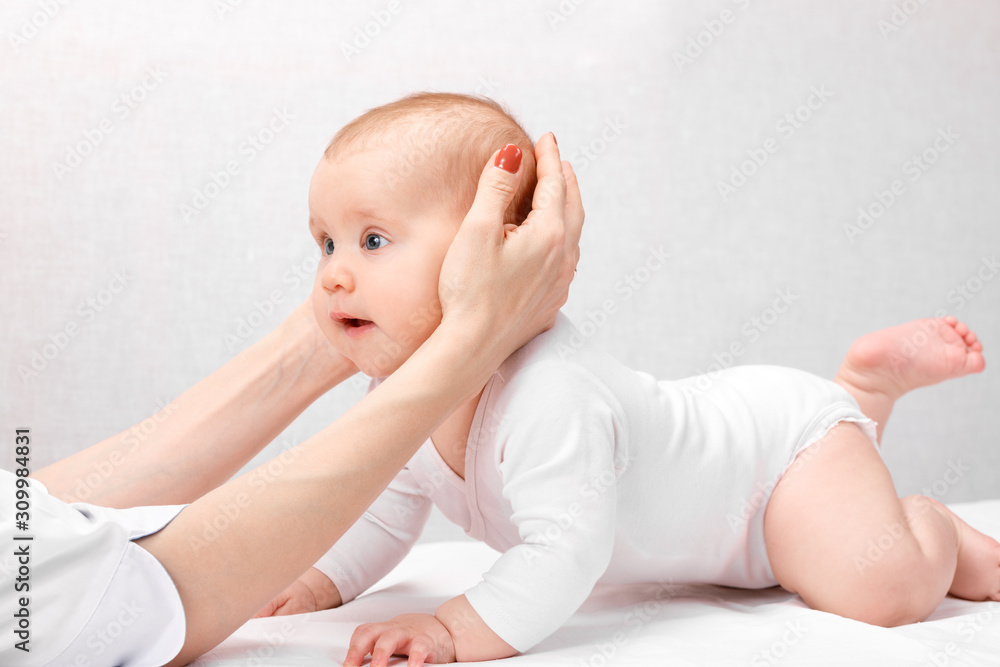 Little baby receiving osteopathic treatment of head and neck - obrazy, fototapety, plakaty 