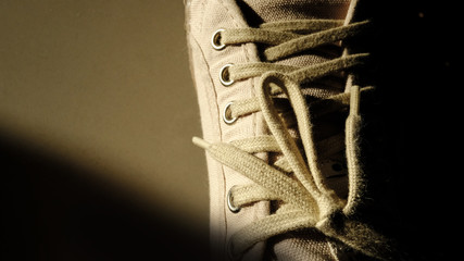 Streaming light coming through on sneaker canvas shoes with blank background.