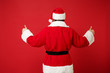 © ViDi Studio - Back rear view of elderly gray-haired Santa man in Christmas hat posing isolated on red wall background studio portrait. Happy New Year 2020 celebration concept. Mock up copy space. Showing thumbs up.