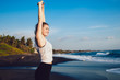 Healthy happy woman stretching arms at seaside