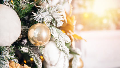 Decorated Christmas tree white and gold color, close-up of toys and decor, fireplace in background