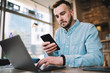 © GalakticDreamer - Freelance adult male typing on laptop while surfing smartphone in cafe