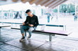 © GalakticDreamer - Young man writing on notepad while sitting on bench