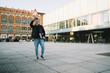 © GalakticDreamer - Smiling student waving hand and carrying laptop