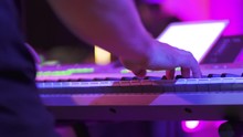 Musician Play On The Synth In Club, Slow Motion And Close Up. Purple Light.