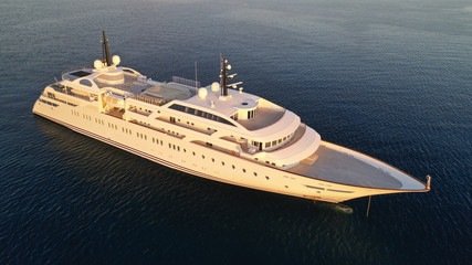 Aerial drone top down photo of luxury yacht docked in Aegean deep blue sea at sunset with beautiful golden colours, Greece