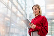 © Westend61 - Young businesswoman wearing red shirt using tablet
