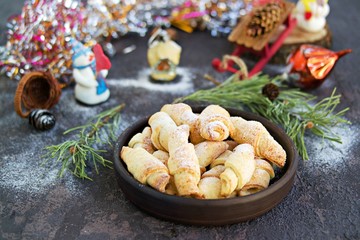 Wall Mural - Cottage cheese cookies in the shape of bagels in a brown ceramic bowl on a dark concrete background in the New Year and Christmas style. Recipes with cottage cheese.