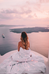 Canvas Print - Young woman wrapped in sheets with blonde hair in santorini greece