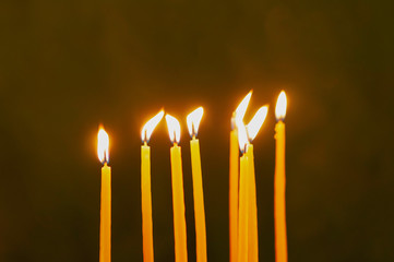 Thin yellow candles on green background