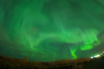 aurora borealis in night northern sky. ionization of air particles in the upper atmosphere.
