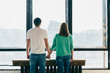 © GalakticDreamer - Couple standing in front of window hand in hand in apartment
