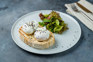 Wall Mural - toast with poached egg on grey table