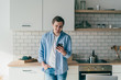 © GalakticDreamer - Young man chatting on phone standing in kitchen