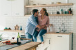 © GalakticDreamer - Cheerful young couple hugging in kitchen