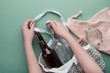 Zero waste grocery shopping concept. Cotton bags and glassware. Hands packing bottles and jar in mesh bag.