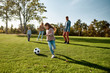 © Svitlana - Faith, Family, Football. Happy family playing with a ball on meadow