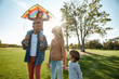 © Svitlana - Loving atmosphere. Happy family playing a kite. Outdoor family weekend