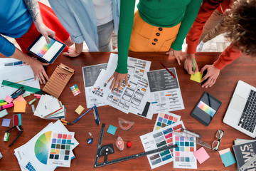 Wall Mural - creating a brand book. top view of design team working on a new project in the creative office. grou