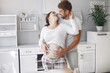 © hetmanstock2 - Cute couple in a kitchen. Lady in a white shirt. pregnant woman.