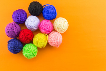 Wall Mural - yarn many color top view on orange background.