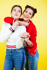 lifestyle people concept: two pretty young school teenage girls having fun happy smiling on yellow background