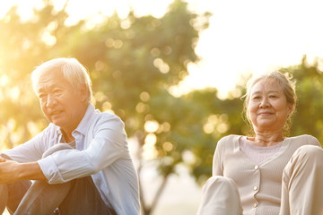 Wall Mural - asian senior man and woman enjoying sunset in park