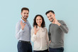 © Pixel-Shot - Portrait of young business people showing OK gesture on color background