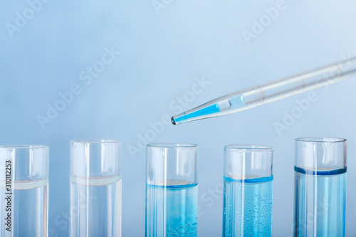 Dripping of color sample into test tube against color background