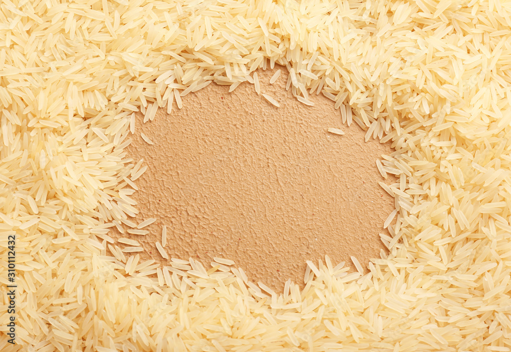 Frame made of raw rice on color background