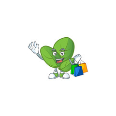 Canvas Print - Cheerful basil mascot waving and holding Shopping bags