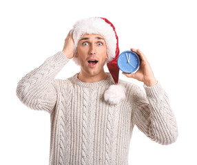 Poster - Surprised young man in Santa hat and with alarm clock on white background. Christmas countdown concept