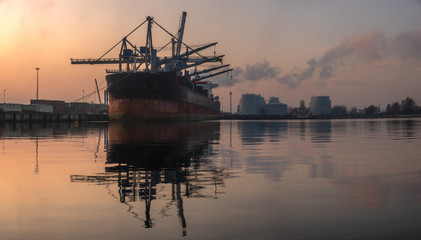 Wall Mural - huge bulk carrier in a seaport at sunrise