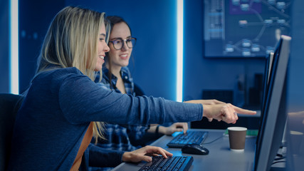 Wall Mural - Two Female IT Programers Working on Desktop Computer in Data Center System Control Room. Team of Young Professionals In Software and Hardware Development, Doing Coding