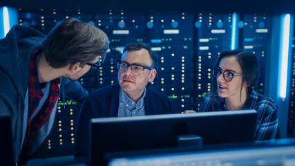 Fototapete - Male, Female IT Engineers / Programmers Having Discussion about Coding on PC. Technical Department with Data Server Racks. Software Development / Code Writing / Website Design / Database Architecture