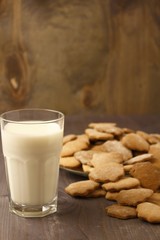 Wall Mural - Transparent glass cup with milk and ginger spicy cookies on a wooden table