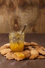 Wall Mural - Orange jam in a glass jar with a spoon.  On the table with ginger homemade cookies