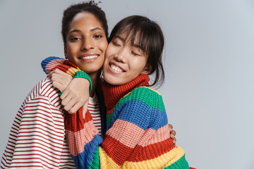 Wall Mural - Portrait of two multinational happy women hugging and laughing