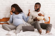 © Prostock-studio - Joyful man eating popcorn while pregnant woman turning away