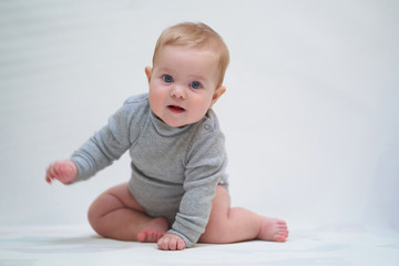 Wall Mural - a six-month-old baby learns to crawl. emotional portrait of a child